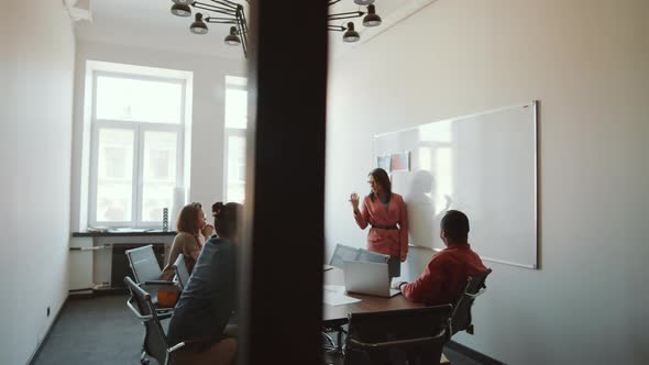 Businesswoman Giving Presentation to Colleagues in Meeting Room