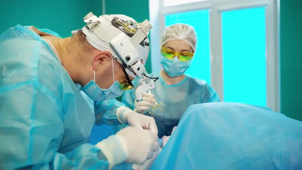 Surgeon during medical procedure. Surgeon performing cosmetic surgery in hospital operating room