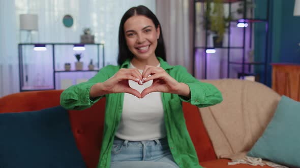 Young Woman Makes Symbol of Love Showing Heart Sign to Camera Express Romantic Positive Feelings