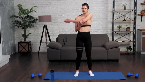 Young Fit Woman in Sportswear Doing Warmup Before Workout on Yoga Mat at Home