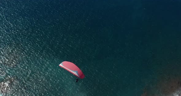 Paraglider Flying Over the Ocean. Aerial View