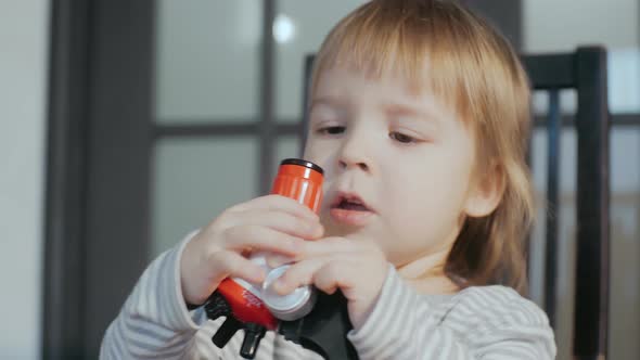 Cute Toddler Boy Using a Toy Baby Microscope