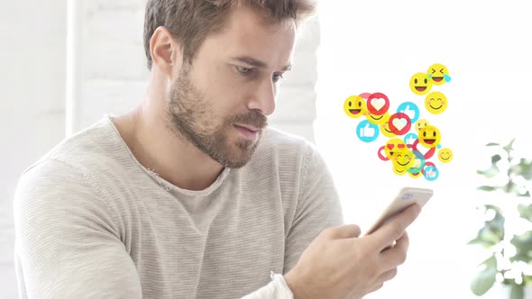 Positive Man Using Smartphone, Flying Emojis, Smileys and Likes