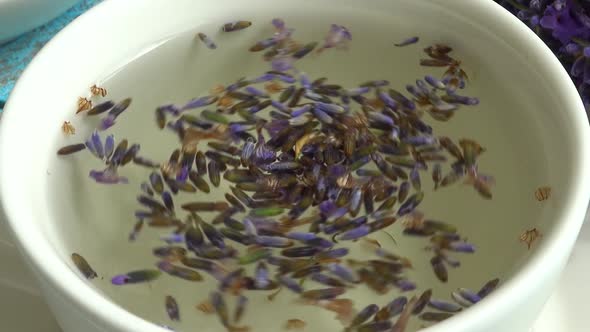 Tea from fresh lavender flowers on a vintage wooden background. Tea is brewed in hot water in a cup.