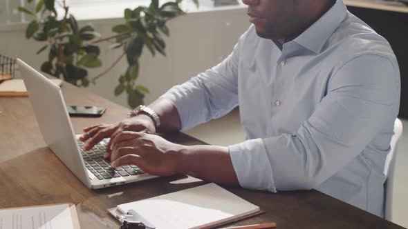 Close Up of Black Male Office Worker Using Laptop