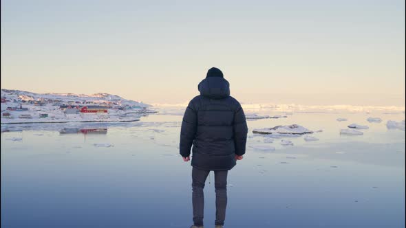 Man In Warm Clothing On Coastline Looking Out To Sea