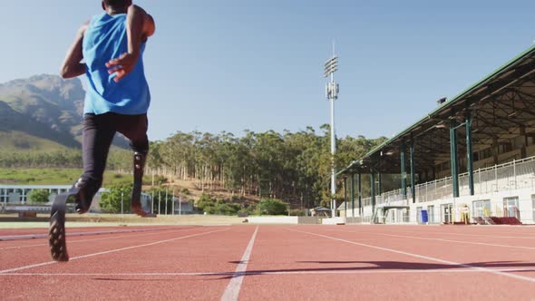 Disabled mixed race man with prosthetic legs running on race track