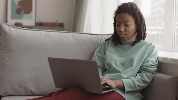 Young African Woman Using Computer at Home