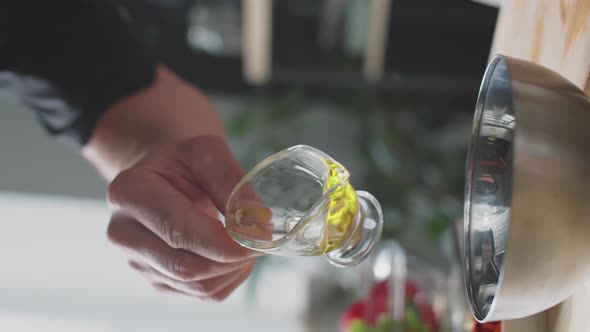 Man Pouring Olive Oil into Bowl