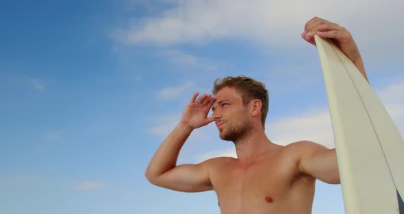 Man standing with surfboard at beach 4k