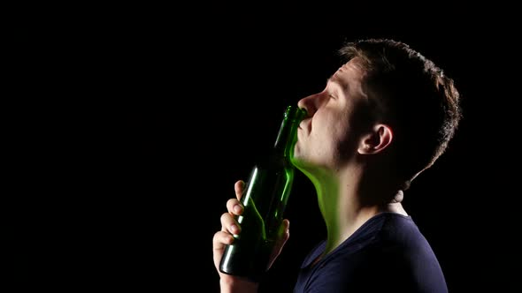 Sad Young Man Drinking Wine with a Throat. Black. Close Up