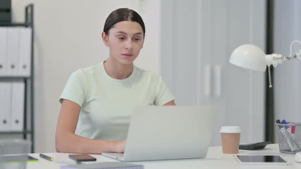 Young Latin Woman with Laptop Looking at Camera 