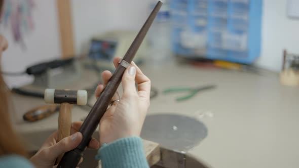 Jeweler With Mallet Hammer And Ring Mandrel Ruler Finger Crafting On Her Workbench