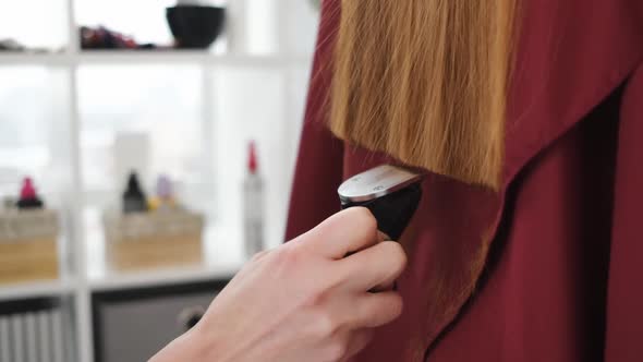 Hairdresser Trims Hair Ends with Hair Clipper
