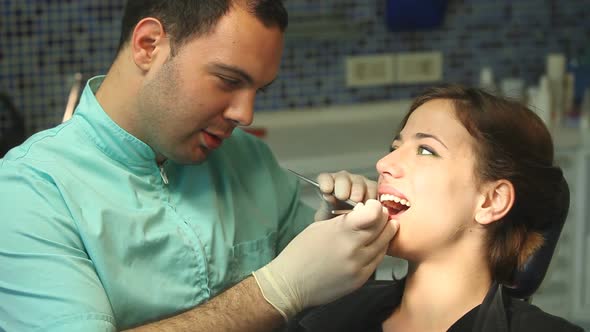 Close up of female dentist and male surgeon examining teeth of a little girl