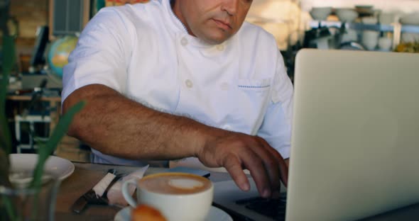 Chef working on laptop at counter 4k