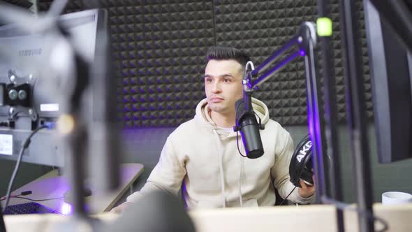 A Radio DJ is Preparing to Conduct a Live Broadcast in a Radio Studio