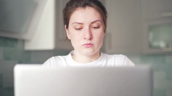 A Woman Performs Work While at Home in Quarantine. Freelancer Does the Job Remotely at Home Kitchen