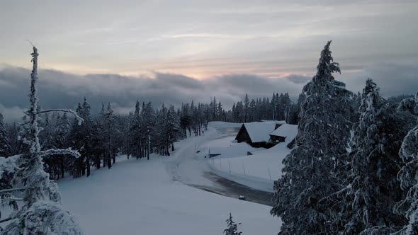 Aerial video of wooden hut covered with snow, drone shot of Crater Lake, Oregon