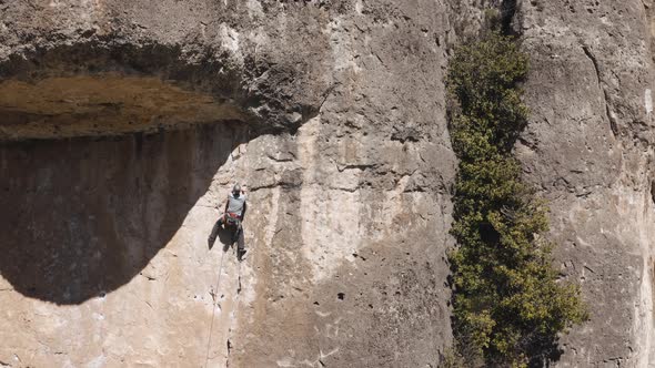 Drone view of a man climbing on a rock in Cuenca, Spain