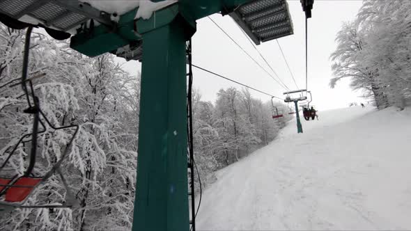 Ascending on a Chair Lift with Trees Covered in Snow