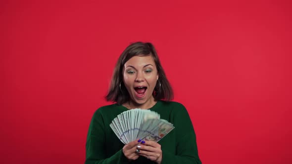 Excited Girl in Green Sweater Showing Money - U.S. Currency Dollars Banknotes