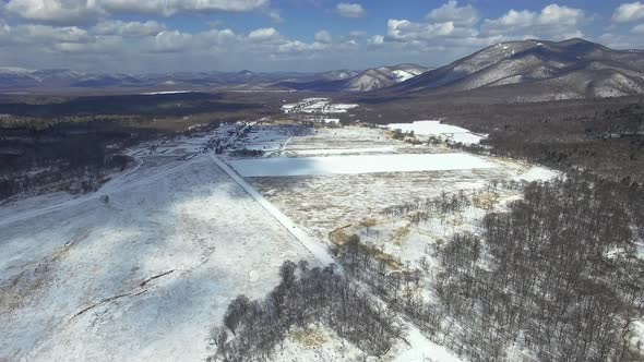 Winter Drone View of a Rural Valley with Road Forest and Hills