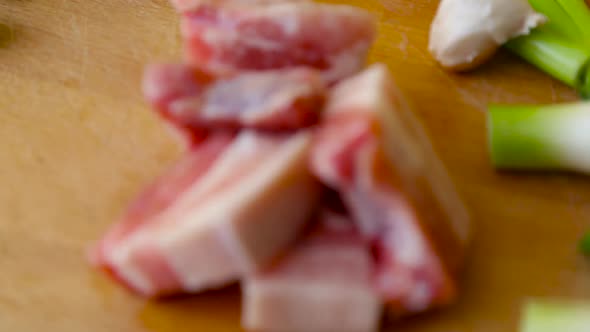 Focus in on Cut slices of pork belly on a wooden cutting board