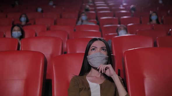 Portrait of Asian Woman in Mask in Movie Theater
