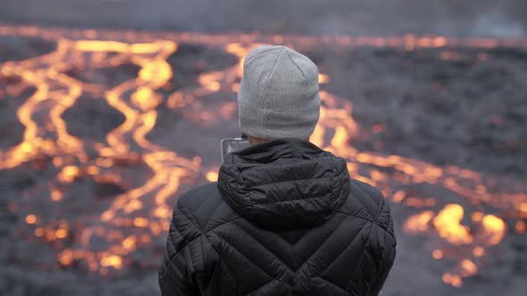 Photographer Controlling Drone And Looking Out Over Lava Field