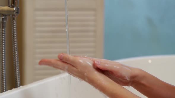 Closeup of a Woman Washing Her Hands in the Bathroom to Prevent the Covid19 Virus Infection