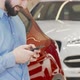 Cropped Shot of a Happy Man Using Smart Phone at Car Dealership - VideoHive Item for Sale