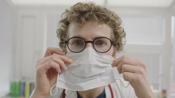 Doctor Putting On Face Mask To Protect Against Coronavirus