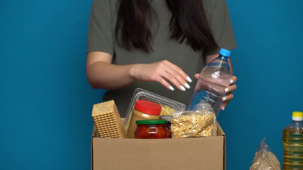 Volunteer Putting Food in a Donation Box. Charity Concept