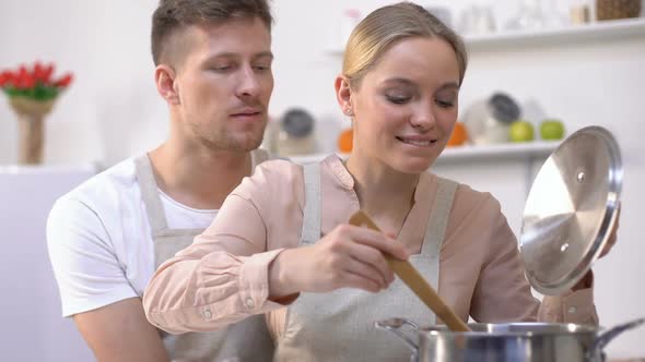 Man Hugging His Woman When She Trying Soup, Happy Couple Cooking Together, Love