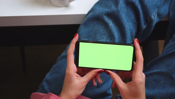 Close Up Woman Hands Holding Chromakey Green Screen Smartphone Watching Content or Video at Home