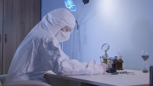 Side View of Doctor in White Antiviral Suit Writing Down Medical Information