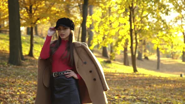 Fashion Lady in Stylish Seasonal Clothes Posing in Autumn Park and Flirting