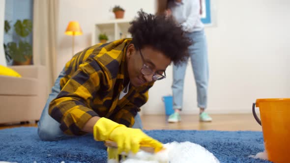 Happy Diverse Married Couple Cleaning Apartment Together