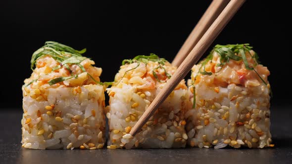 Take One Sushi Roll From Black Slate Board Using Chopsticks