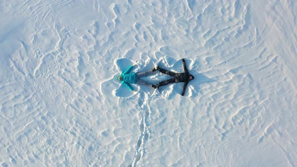 A Family Makes a Figure of a Snow Angel in a Clearing in the Forest