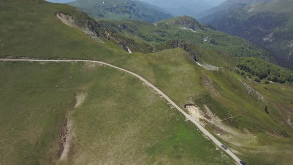 Aerial view of a group of cars rides along the mountains Kolasin in spring in Montenegro