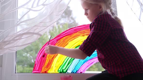 Girl Painting Rainbow on Window During Covid19 Quarantine at Home