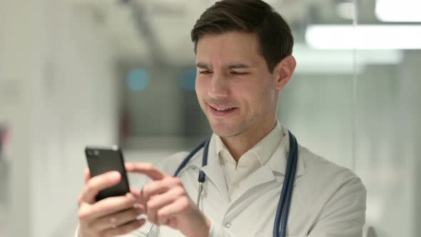 Portrait of Male Doctor Using Smartphone in Office