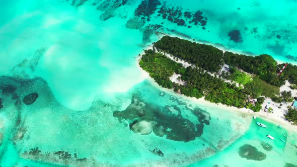 Wide angle aerial tourism shot of a white sandy paradise beach and turquoise sea background in colou