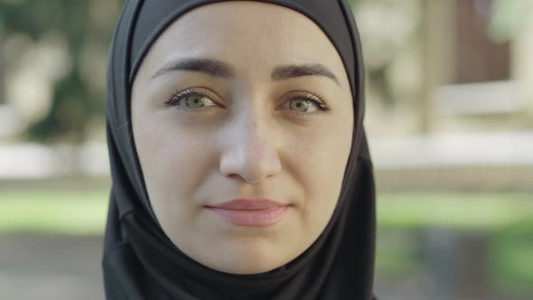 Close-up Face of Young Beautiful Woman in Traditional Hijab Looking at Camera and Smiling. Portrait