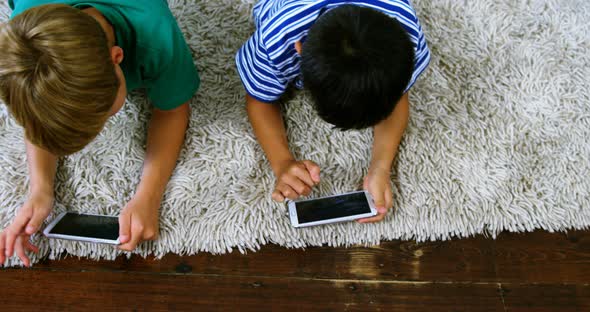 Siblings using mobile phone in living room