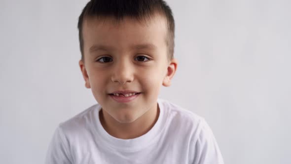 Boy Closeup Brown Eyes Look at the Camera Fooling Around Smiling Emotionally on White Background 4