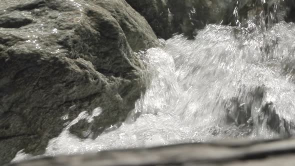 Detail shot in slowmotion of how the water falls between rocks in the Venosc river, French Alps. Pro