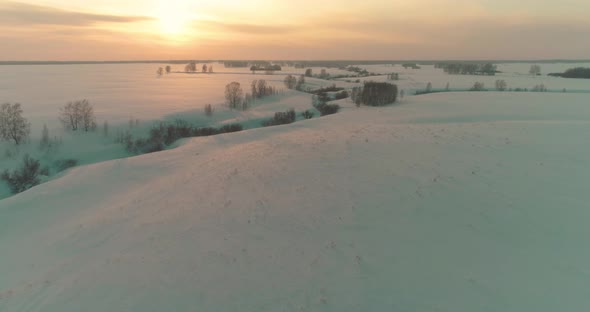 Aerial View of Cold Arctic Field Landscape Trees with Frost Snow Ice River and Sun Rays Over Horizon